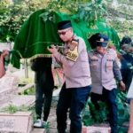 Kapolsek Poso Pesisir AKP Risdiyanto (kanan depan) memikul keranda korban ke tempat pemakaman di Desa Tokorondo, Poso, Jumat (16/5/2025). (Foto: Humas Ops Madago Raya)